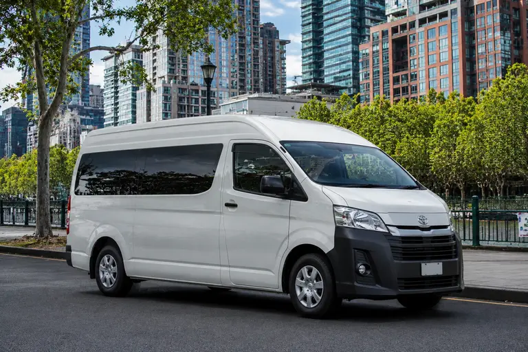 Maxi taxi Melbourne, white 11 seater van parked near the city